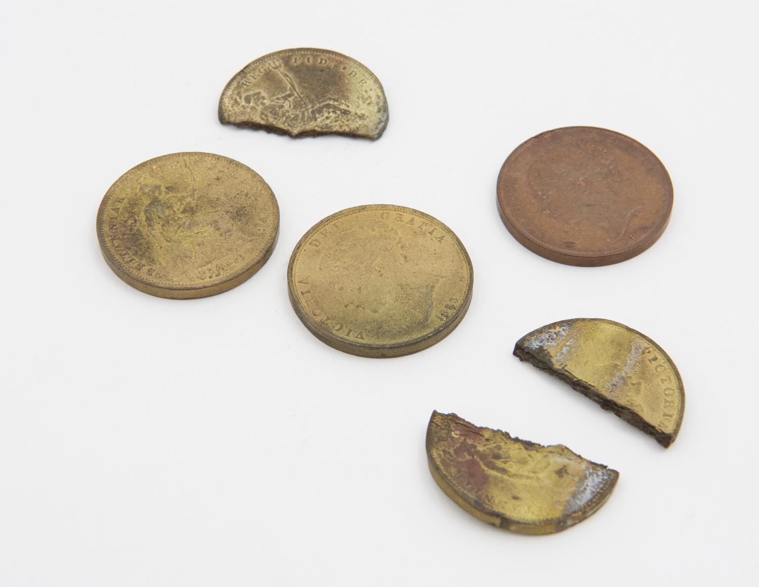 Copper pennies cemented into brass in a crucible (specimen)